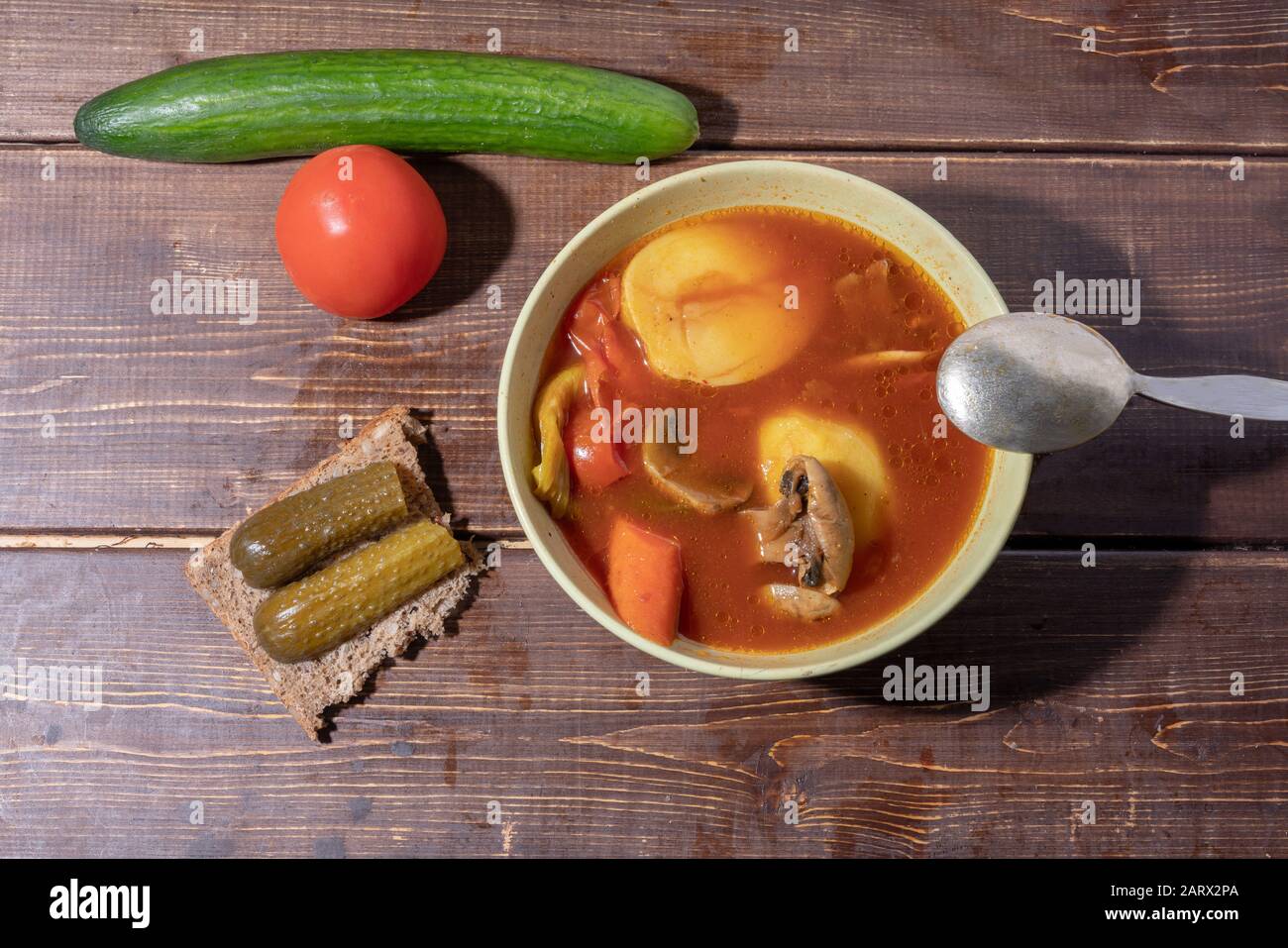 Zuppa con funghi e sandwich con cetrioli salati su tavole di legno scuro Foto Stock