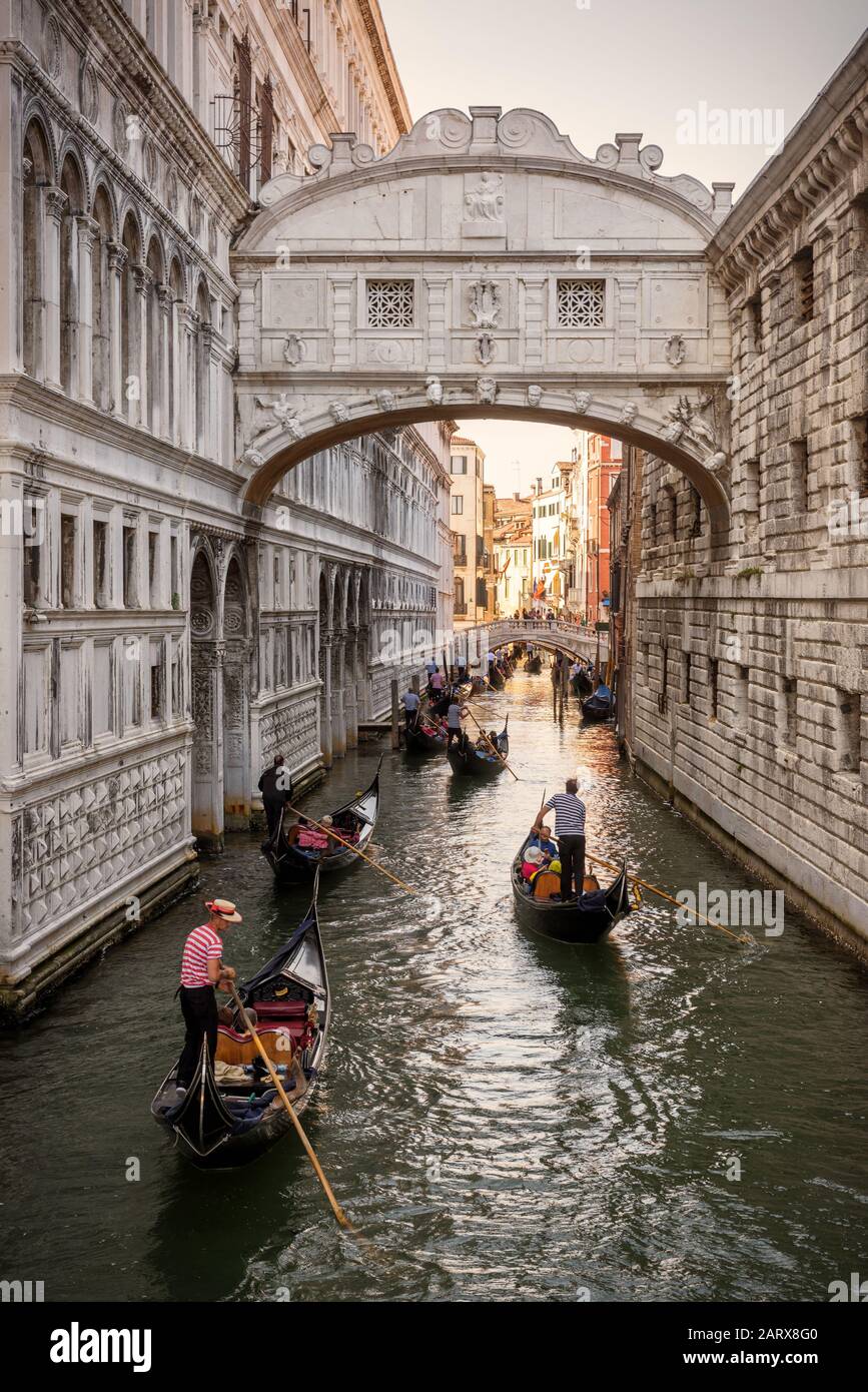 Venezia, Italia - 18 maggio 2017: Le gondole con i turisti navigano lungo lo stretto canale sotto il famoso Ponte dei Sospiri presso il Palazzo Ducale di`s. La gondola Foto Stock
