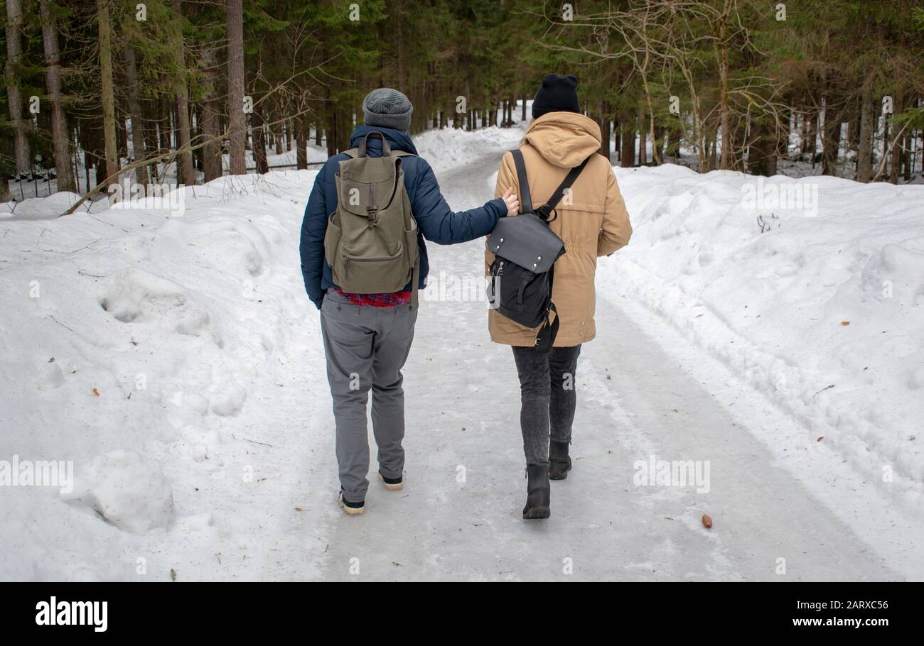 due giovani ragazze hippster dalla parte posteriore che hanno camminato nella foresta di inverno con i sacchetti. Foto Stock