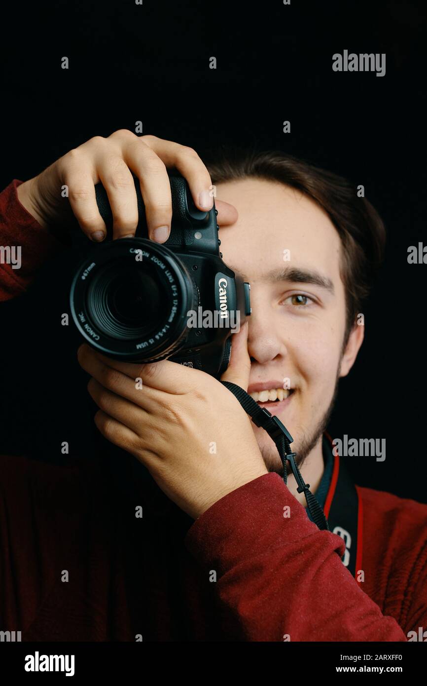 Bishkek, Kirghizistan - 15 dicembre 2019: L'uomo tiene in mano una macchina fotografica canon e scatta immagini in uno studio fotografico Foto Stock
