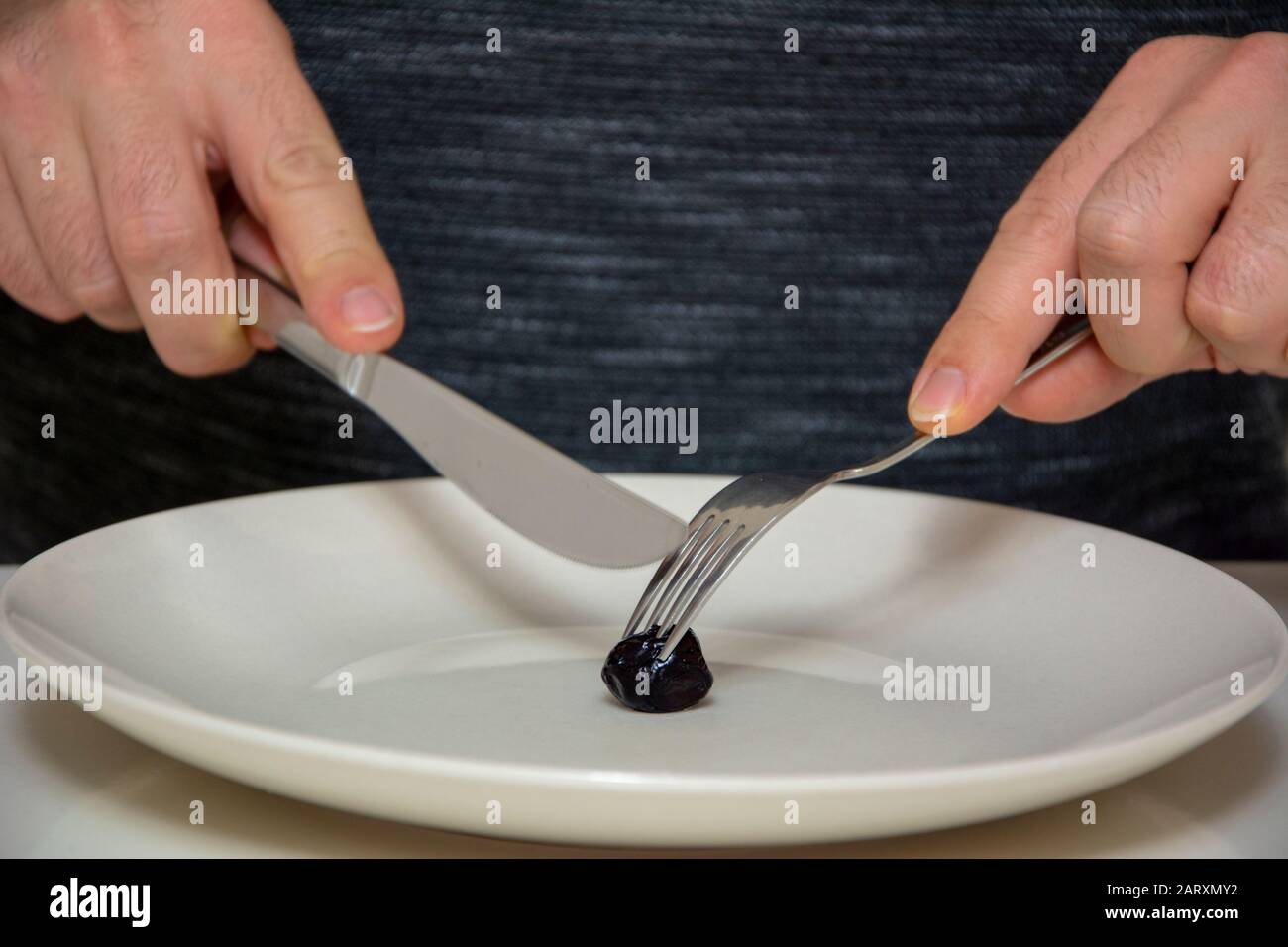 L'uomo mangia le uniche olive sul piatto Foto Stock