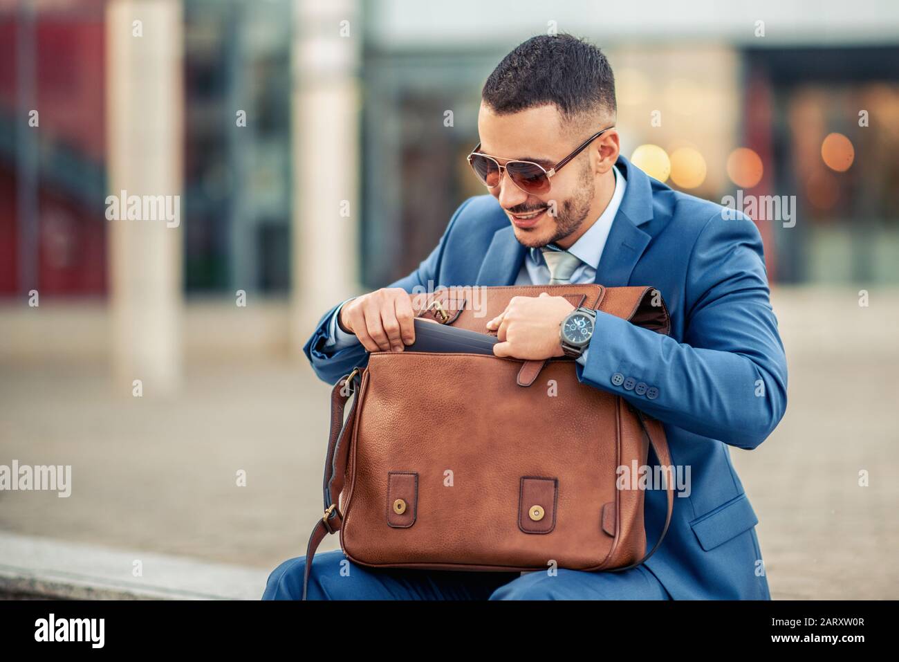 Uomo d'affari che tiene la sua valigetta,close up.He sta continuando il suo lavoro. Foto Stock