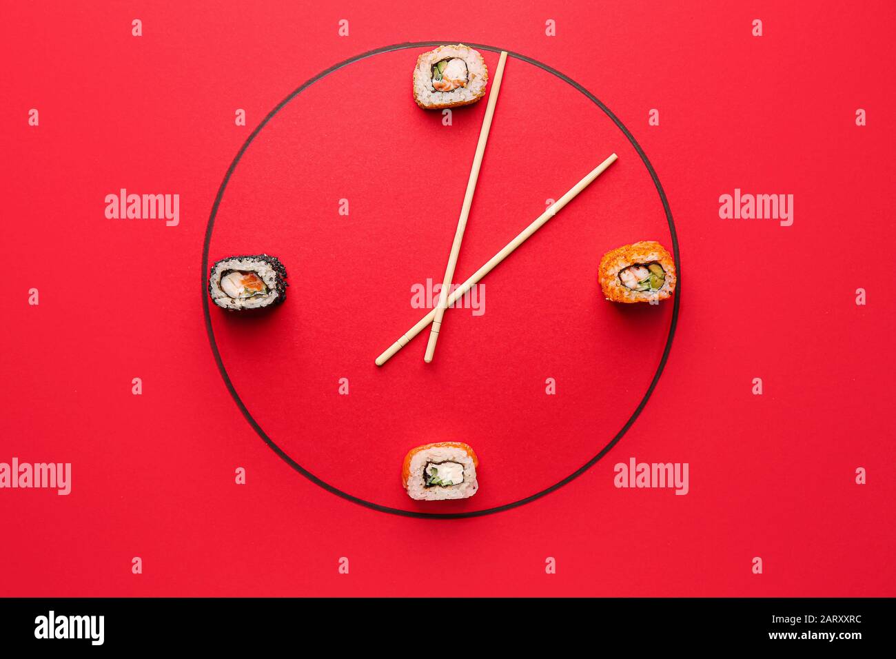 Orologio creativo a base di gustosi sushi e bacchette su sfondo colorato Foto Stock