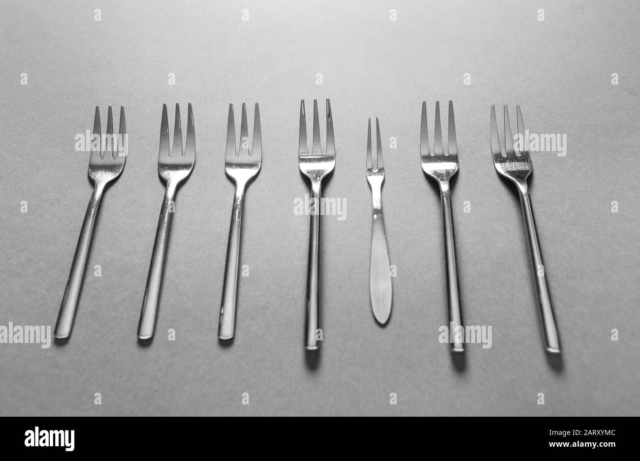 Forcelle diverse su sfondo grigio. Concetto di unicità Foto Stock