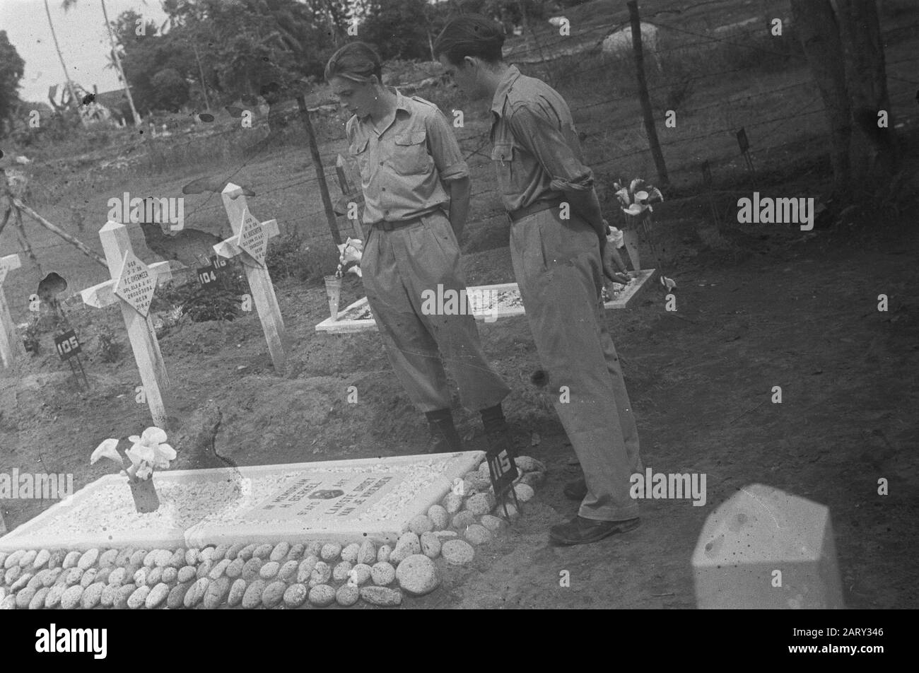 Dr. Mansuer a Medan (Wali Negara Sumatera Timoler); celebrazione di Natale 3.4-i R.I. Canoa-Plateau; Ospedale militare; omaggio floreale sulle tombe Due soldati in piedi su un cimitero vicino alla tomba di H. Berkel dalla 9th afd. Artiglieria Annotazione: S 21 anni Nato il 1 maggio 1926 a l'Aia Morì il 19 agosto 1947 a Sibolangit Data: 25 dicembre 1947 Località: Indonesia, Indie Orientali Olandesi Foto Stock