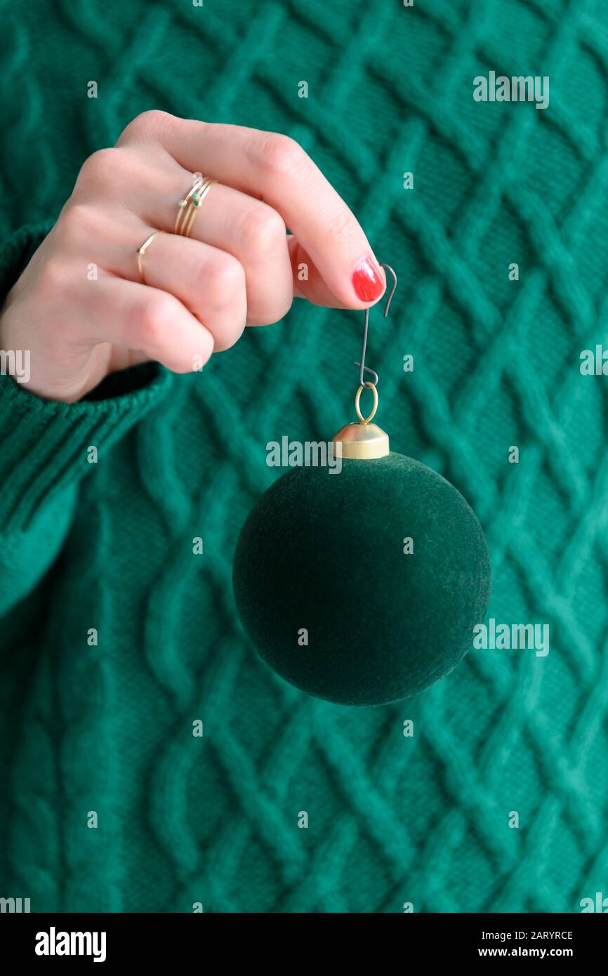 Donna che indossa verde tenente verde bauble Foto Stock