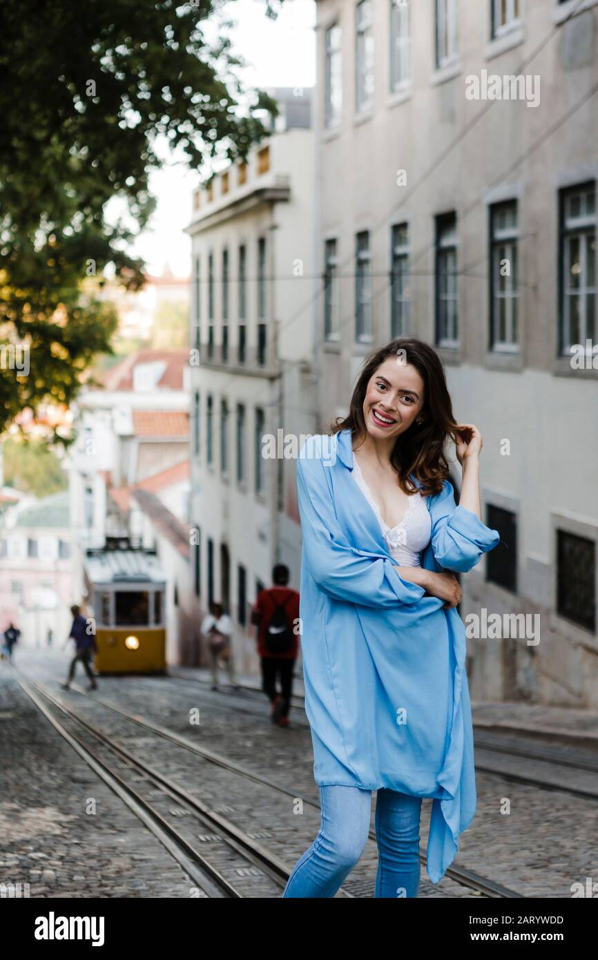 Donna sorridente con camice blu in tram Foto Stock