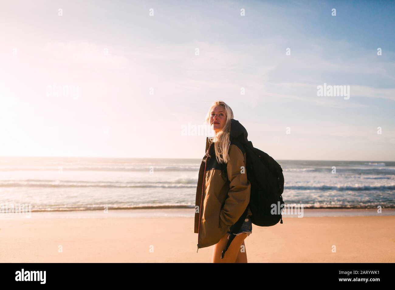 Donna che indossa uno zaino in spiaggia Foto Stock