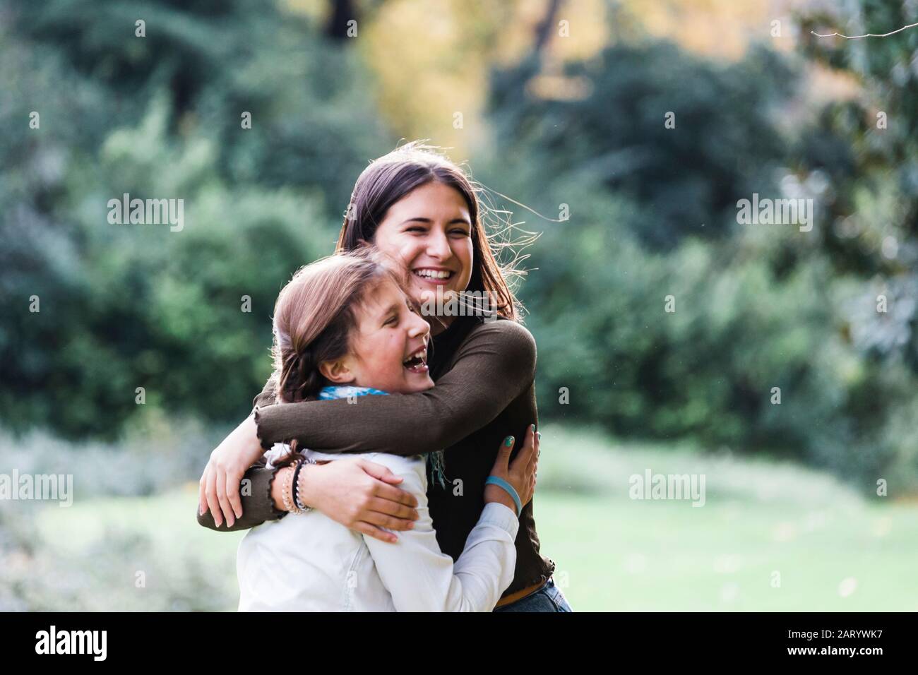Sorelline sorridenti abbracciate da Bush Foto Stock