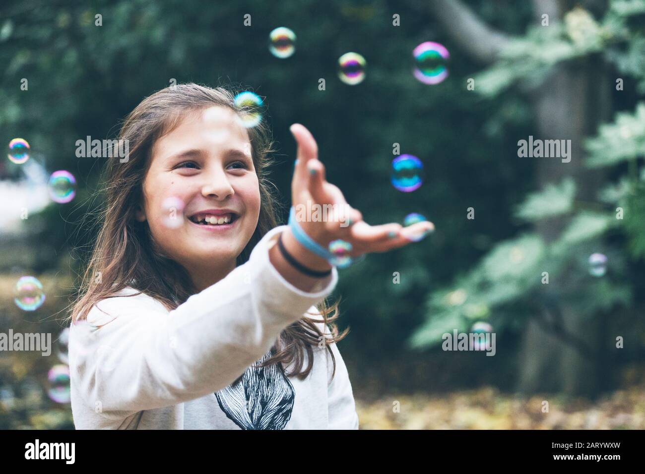 Ragazza sorridente che gioca con bolle Foto Stock