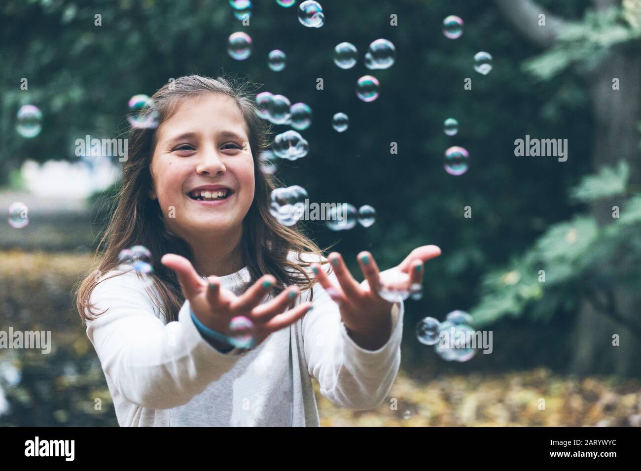 Ragazza sorridente che gioca con bolle Foto Stock
