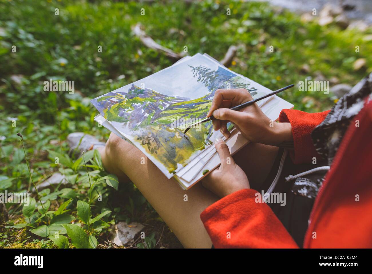 Donna pittura con acquerelli su erba Foto Stock