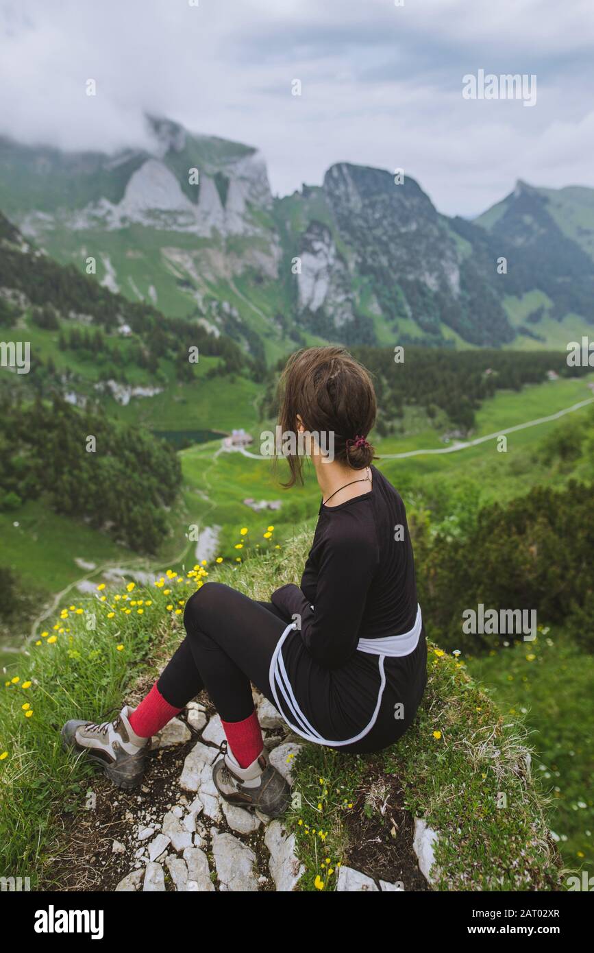 Donna seduta sulla roccia in montagna ad Appenzell, Svizzera Foto Stock