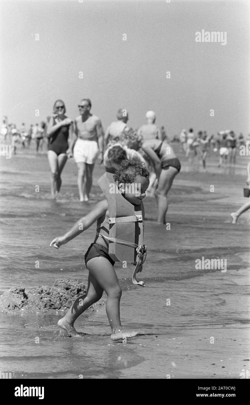 Occupato sulla costa. Panoramica Di Zandvoort Boulevard. Con una grande giacca di vita Mikky esce dall'acqua Data: 22 Luglio 1963 Località: Noord-Holland, Zandvoort Parole Chiave: Boulevards, bambini, giubbotti di salvataggio Foto Stock