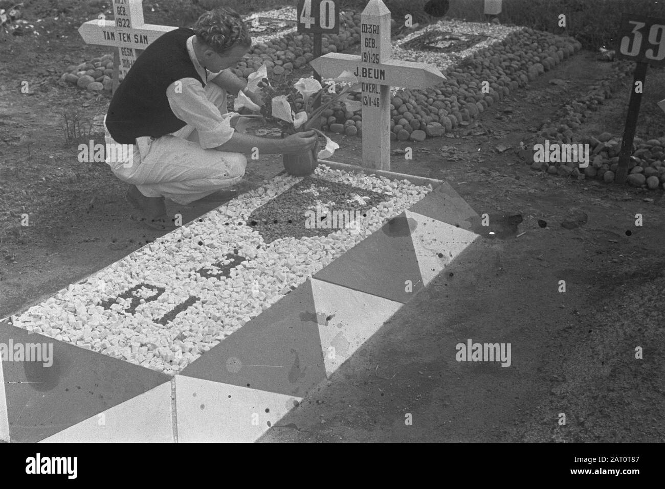 Dr. Mansuer a Medan (Wali Negara Sumatera Timoler); celebrazione di Natale 3.4-i R.I. Canoa-Plateau; Ospedale militare; omaggio floreale sulle tombe UN giovane pone un vaso con fiori sulla tomba di J. Beum di III-3 R.i. (Nato Il 19-1-1925, Morto Il 13-11-1946) Data: 25 Dicembre 1947 Luogo: Indonesia, Indie Orientali Olandesi Foto Stock