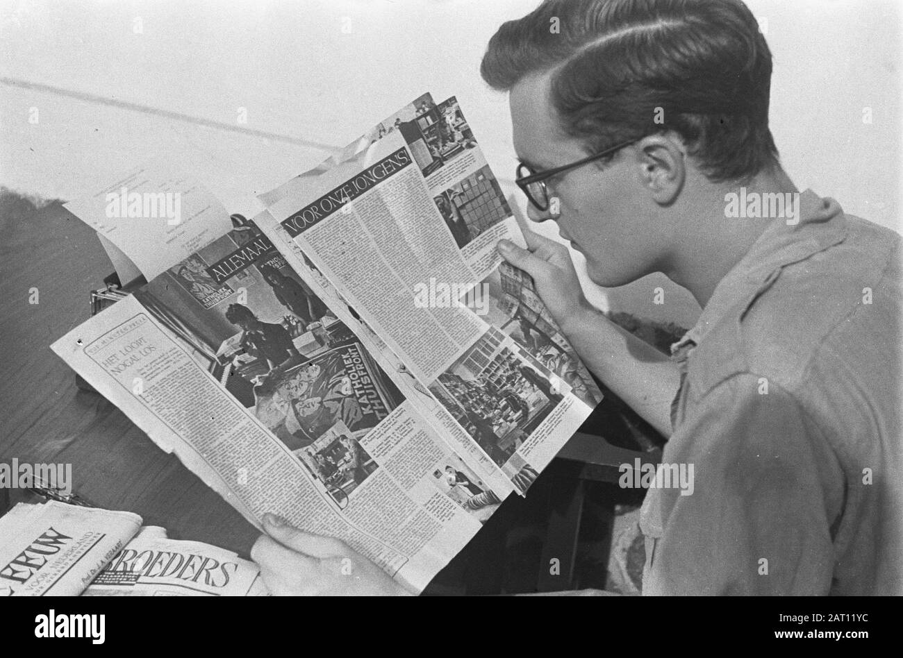 Un editore legge una copia della rivista Brothers of Arms, seduta su una scrivania con macchina da scrivere. Legge un articolo sul servizio Welfare Data: Ottobre 1947 Località: Indonesia, Indie Orientali Olandesi Foto Stock