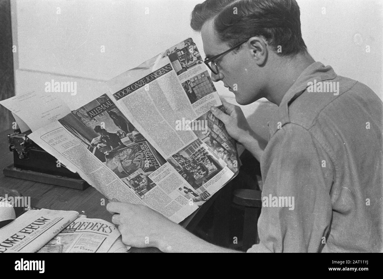 Un editore legge una copia della rivista Brothers of Arms, seduta su una scrivania con macchina da scrivere. Legge un articolo sul servizio Welfare Data: Ottobre 1947 Località: Indonesia, Indie Orientali Olandesi Foto Stock