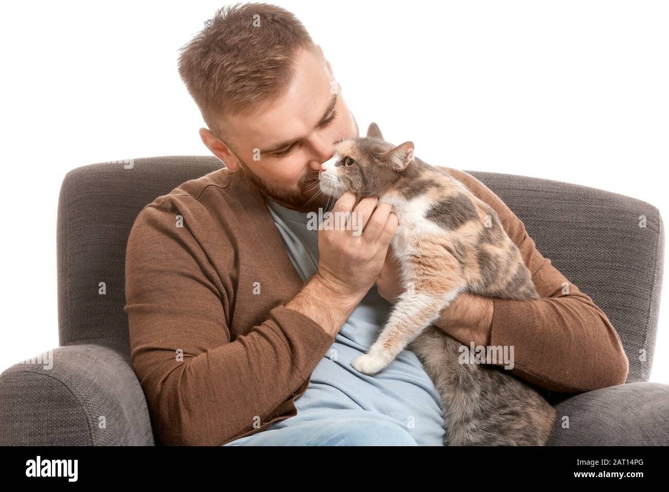 Uomo con gatto carino seduto in poltrona su sfondo bianco Foto