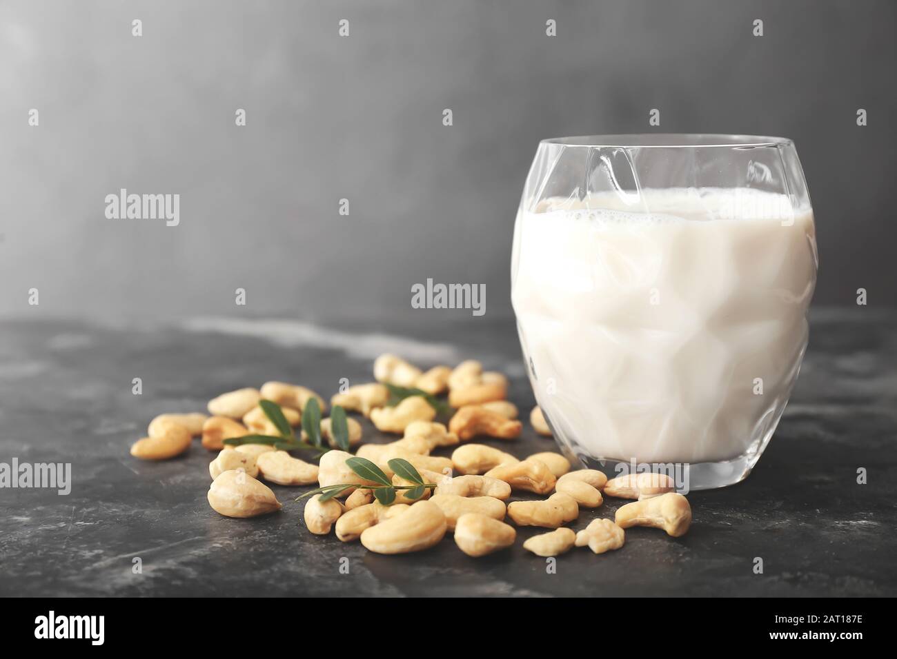 Bicchiere di latte di anacardi su fondo scuro Foto Stock