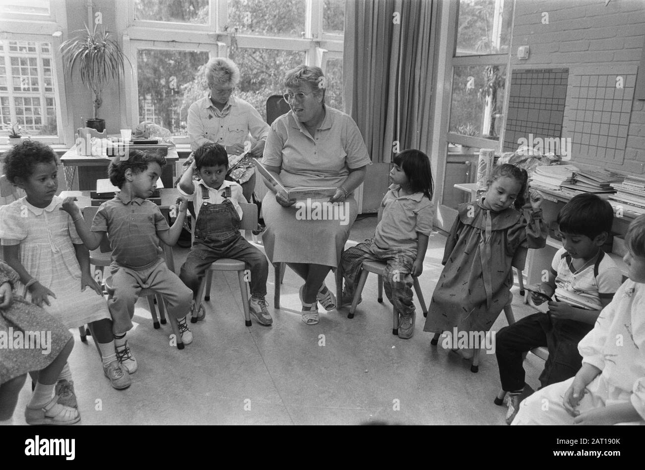 Prima scuola elementare giorno ad Amsterdam; insegnante legge storia per Data: 11 Agosto 1986 Località: Amsterdam, Noord-Holland Parole Chiave: EDUCAZIONE PASIAL Foto Stock
