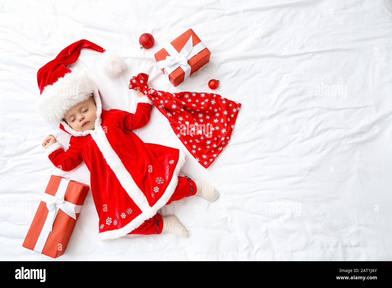 Piccolo bambino carino in costume di Babbo Natale e con regali sdraiati sul  letto, vista dall'alto Foto stock - Alamy