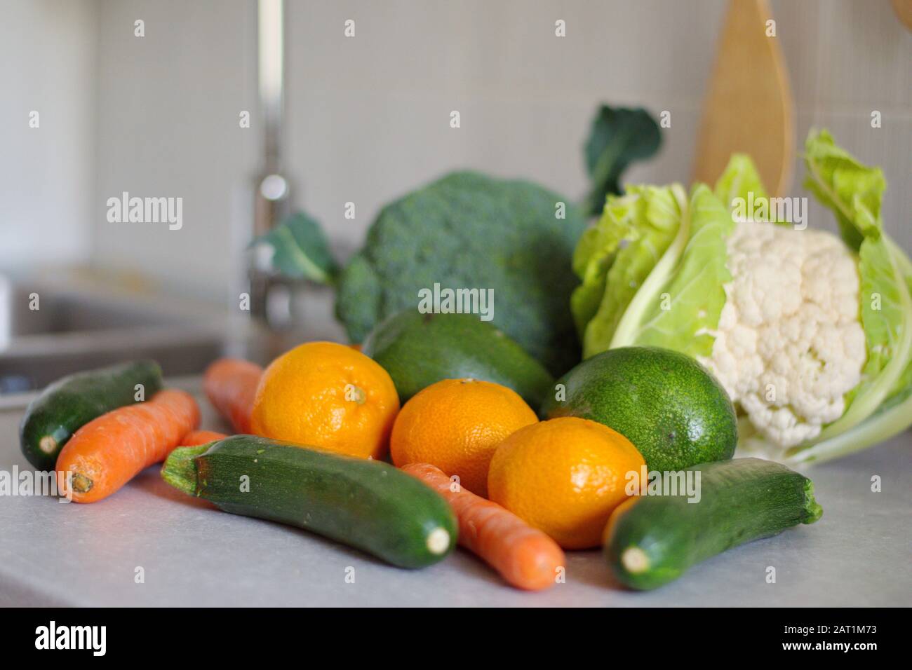 Verdure fresche sane sulla scrivania della cucina vicino al lavandino Foto Stock