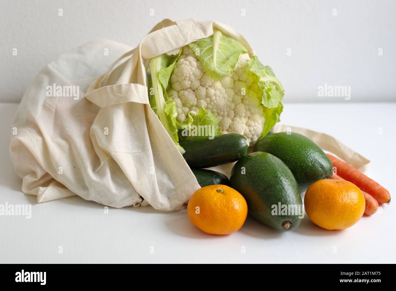 Una sana ortaggi freschi sul tavolo bianco in borsa riutilizzabile Foto Stock
