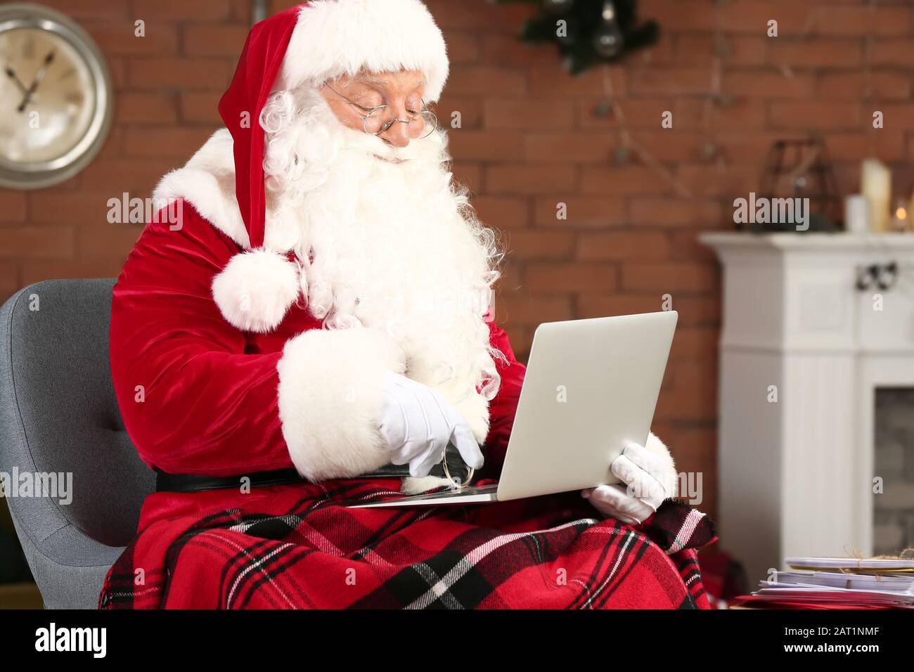 Babbo Natale con il computer portatile in camera decorata per Natale Foto Stock