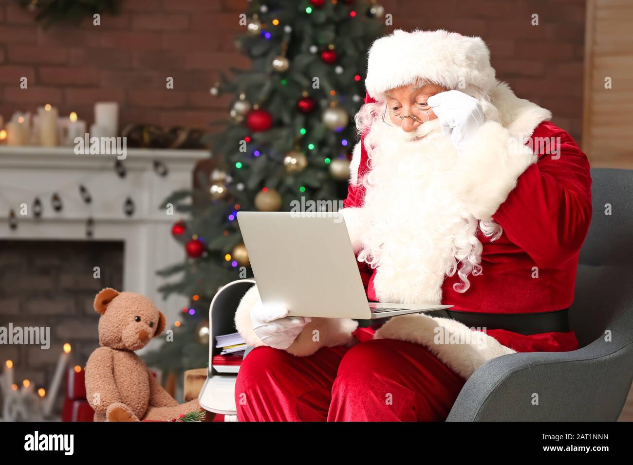 Babbo Natale con il computer portatile in camera decorata per Natale Foto Stock