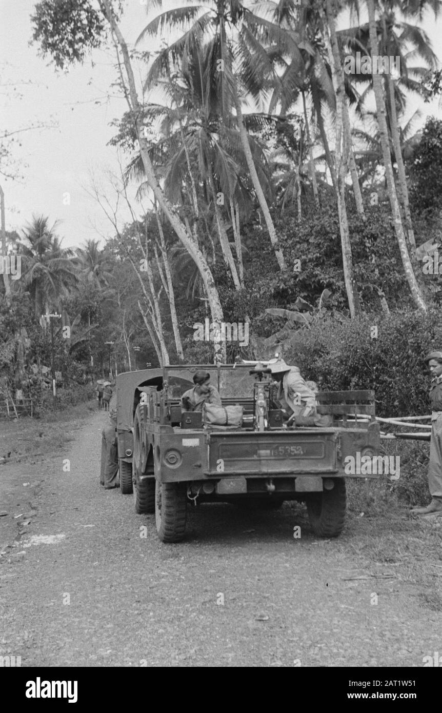 Sport e campo post Evacuazione di una famiglia cinese-indonesiana? Veicoli militari su strada. Nel secchio una bicicletta e un uomo in civile con casco tropicale che imbarco Annotazione: A destra l'esercito che appare su una foto con una ragazza posizione: Indonesia, Indie orientali olandesi Foto Stock