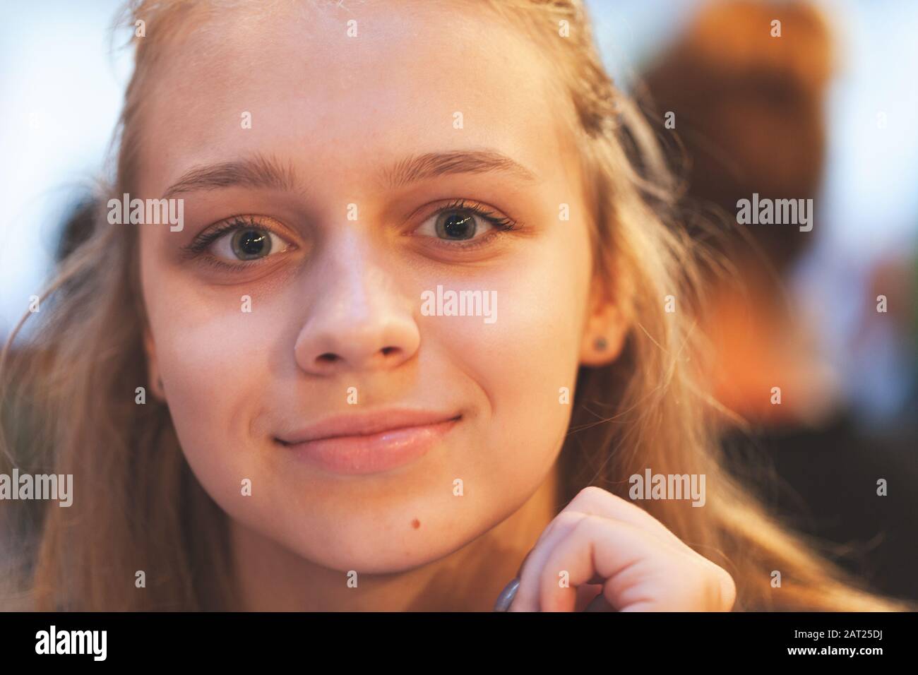 Bella bionda europea ragazza adolescente sorride alla macchina fotografica, primo piano ritratto Foto Stock