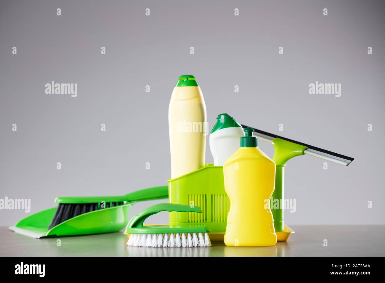 Tema pulizia casa di primavera. Prodotti per la pulizia colorati su tavolo bianco. Luogo per la tipografia. Foto Stock