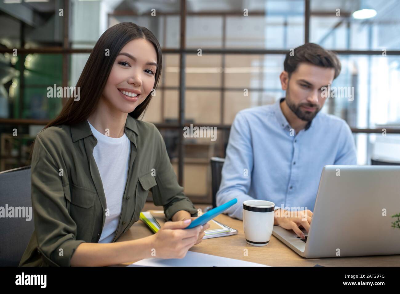 Giovane donna asiatica che ha un tablet e sorridente Foto Stock