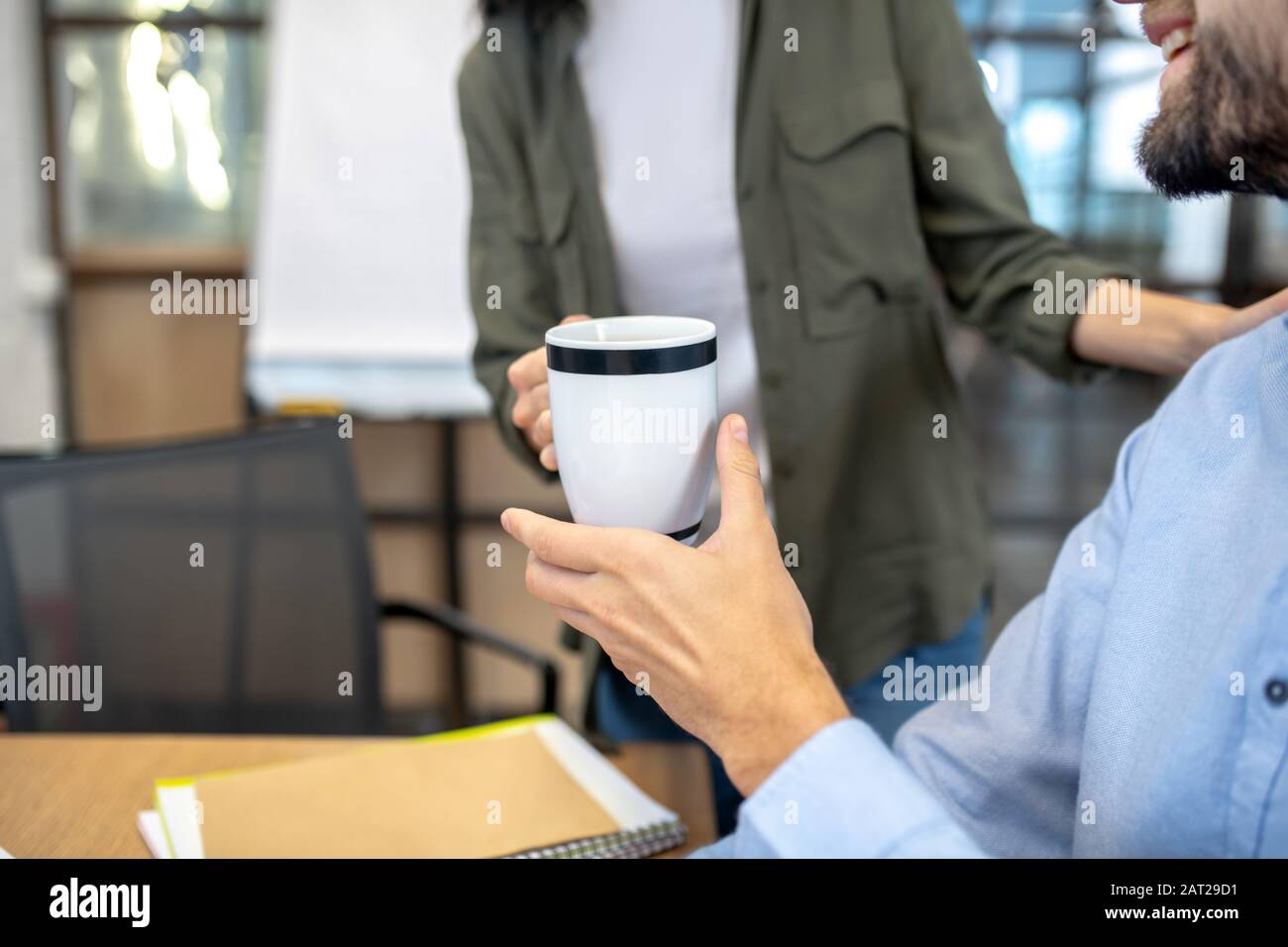 Primo piano immagine di un uomo che tiene una tazza Foto Stock
