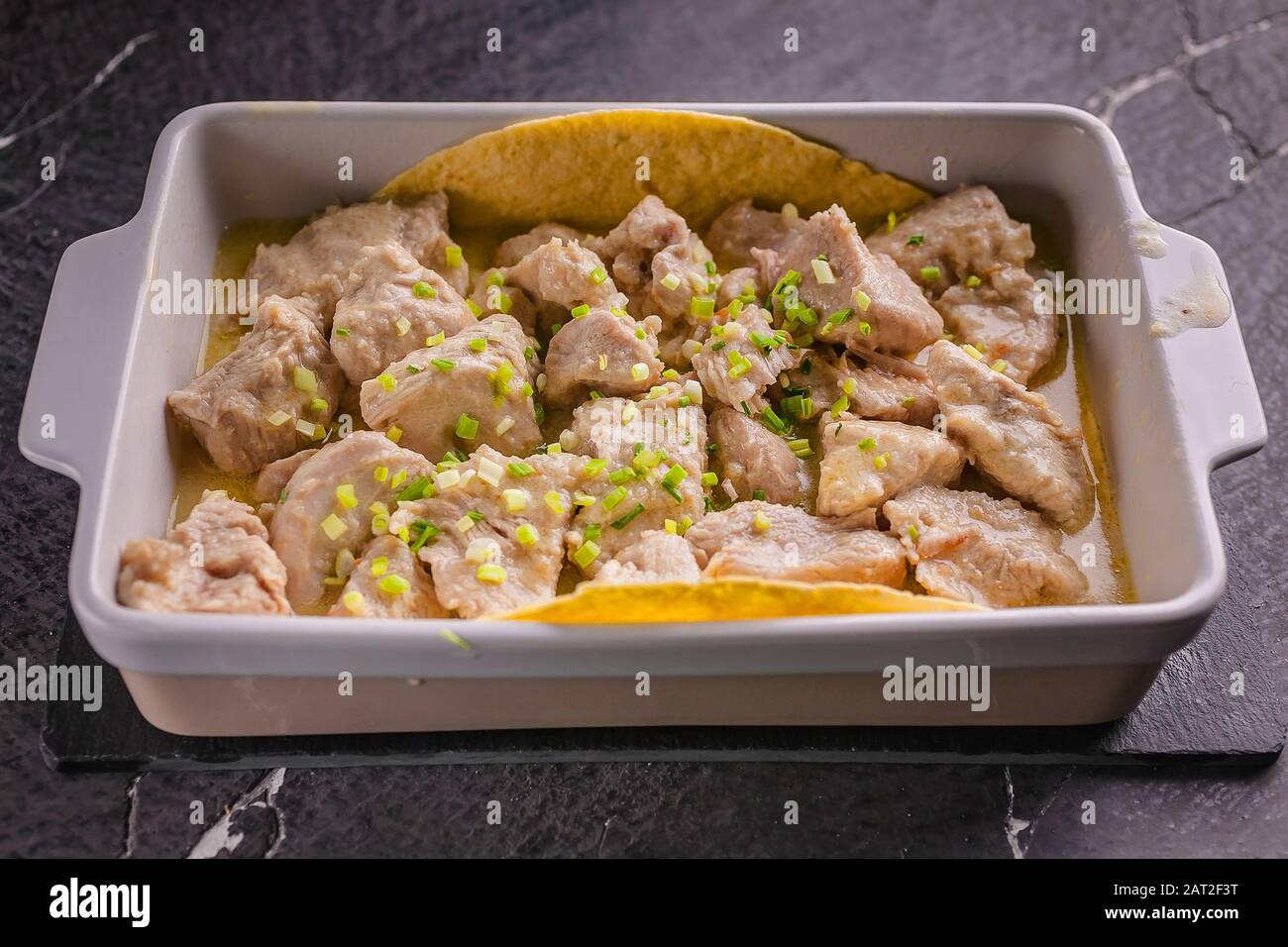 Chiudete la carne bianca stufata di tacchino in una salsa cremosa con erbe e condimenti in un recipiente in ceramica Foto Stock