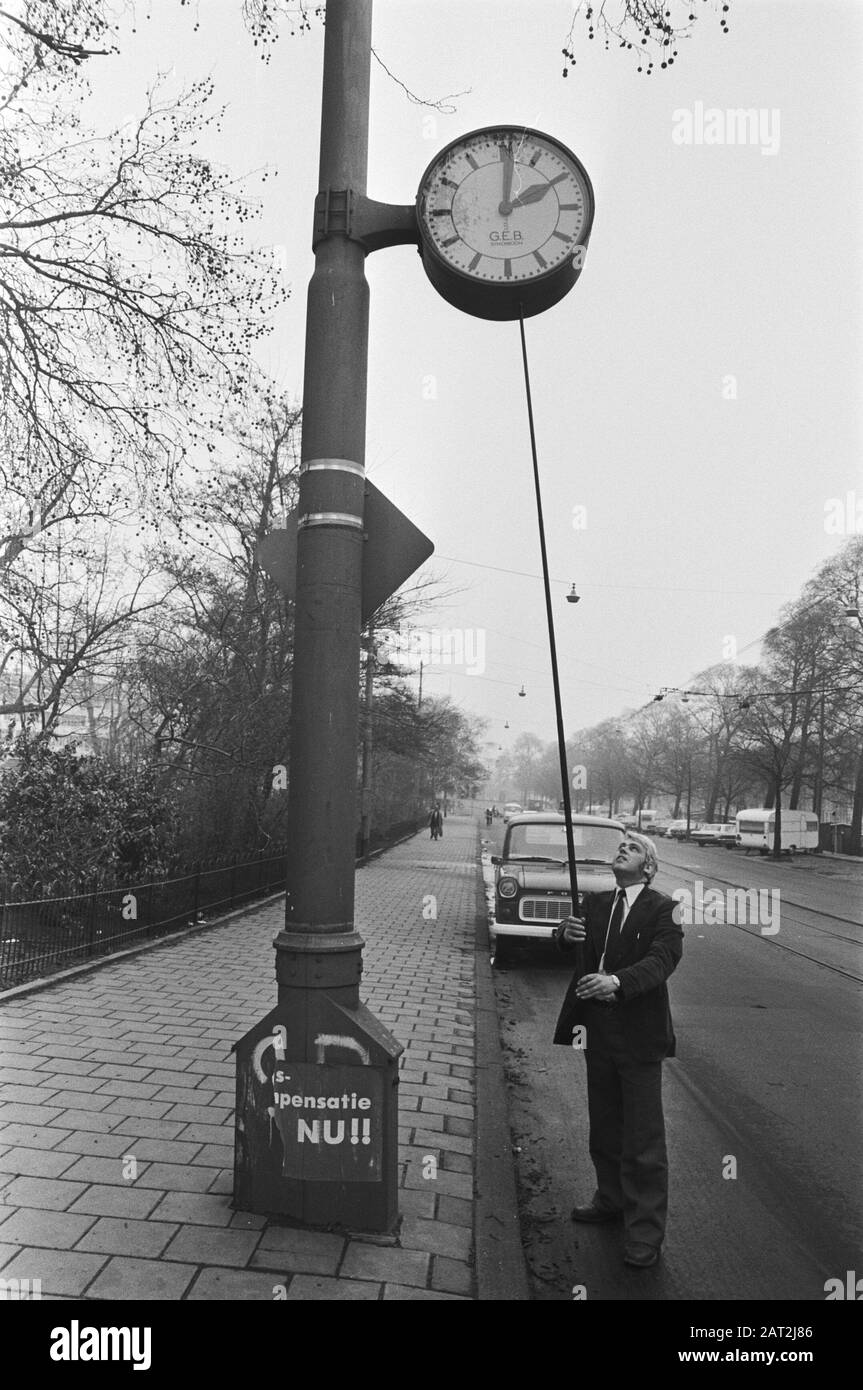 Entrata ora legale 1977 Municipal worker imposta un orologio un'ora avanti Data: 24 marzo 1977 Parole Chiave: Funzionari, automobili, orologi, immagini di strada, ora legale Foto Stock