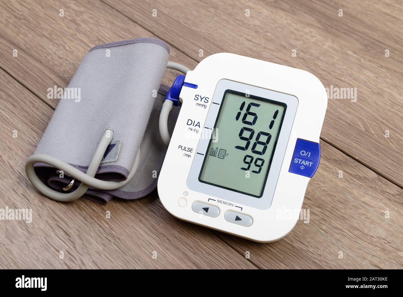 Monitor automatico della pressione sanguigna bianco (tonometro) su tavolo in legno Foto Stock