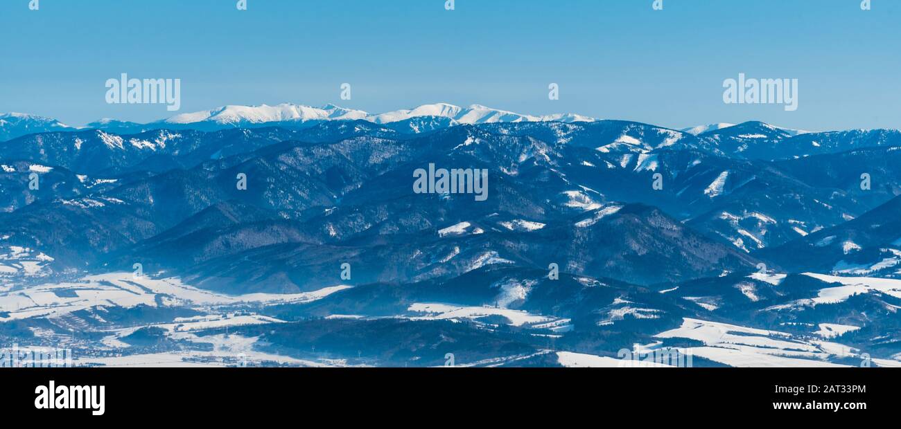 Nizke Tatry e le montagne Velka Fatra più vicine e più basse dalla sella di sedlo Okopy, a monte Mincol, sulle montagne di Mala Fatra, durante la bella giornata invernale Foto Stock