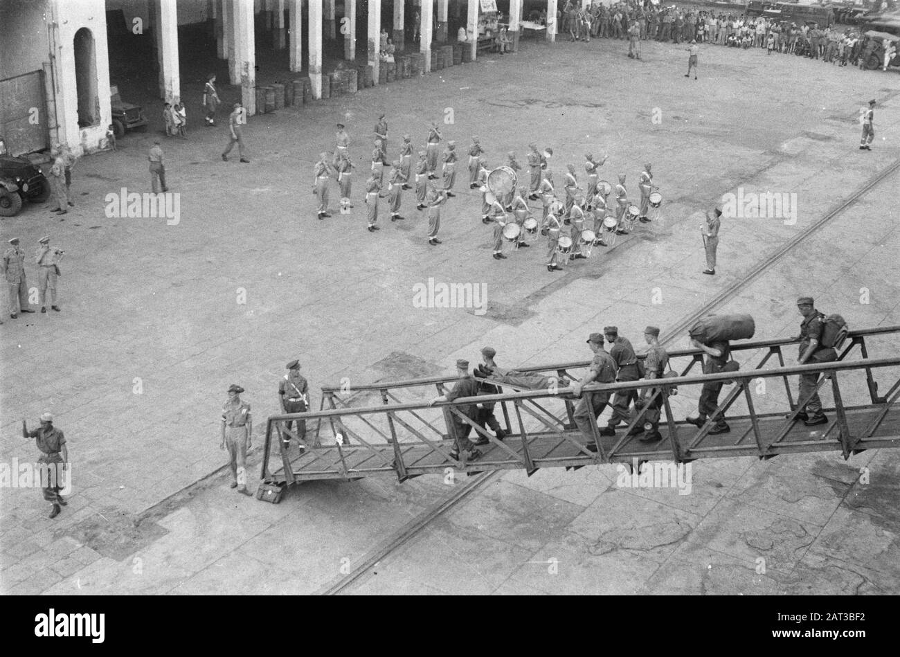 Arrivo del Johan de Witt il Pijperkorps della Divisione del 7 dicembre è sulla banchina per salutare le persone a bordo. I primi uomini, tra cui un malato su una barella, lasciare la nave Data: 21 novembre 1946 luogo: Batavia, Indonesia, Jakarta, Indie orientali olandesi, Tandjong Priok Foto Stock