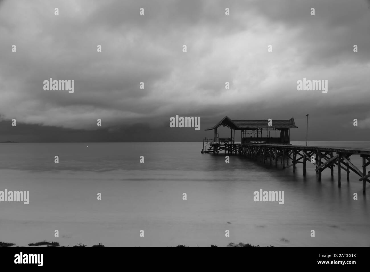 Molo di legno su un'isola tropicale con cielo nuvoloso.Raja Ampat, Papua Occidentale, Indonesia Foto Stock