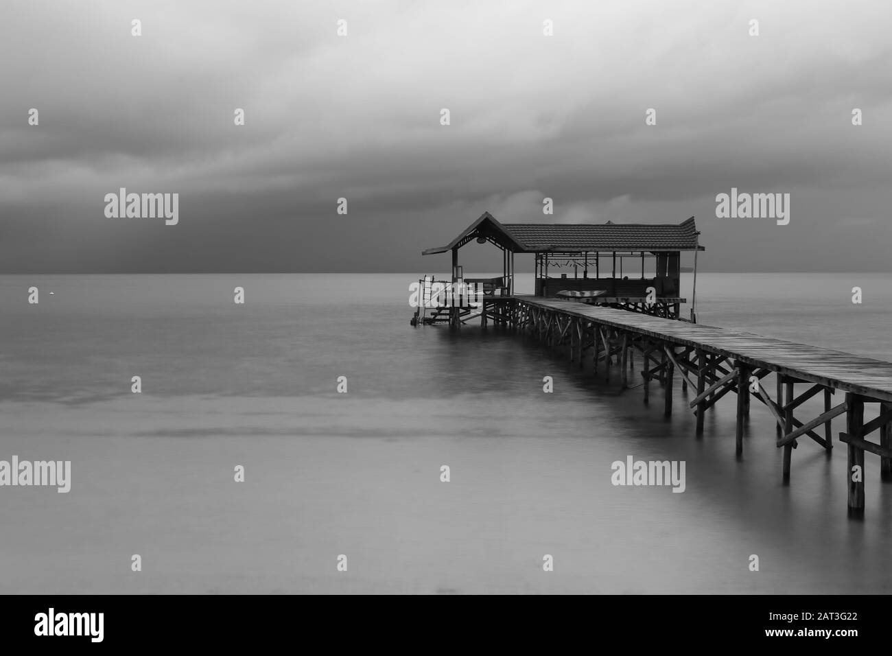 Molo di legno su un'isola tropicale con cielo nuvoloso.Raja Ampat, Papua Occidentale, Indonesia Foto Stock