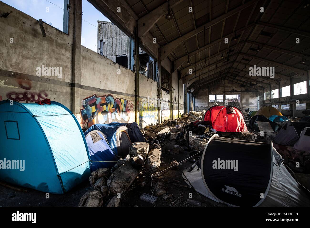 Immigrati curdi iracheni che si rifugiano in tende tra le macerie di un deposito derelict alla periferia di Dunkerque mentre cercano di raggiungere la Gran Bretagna. Foto Stock