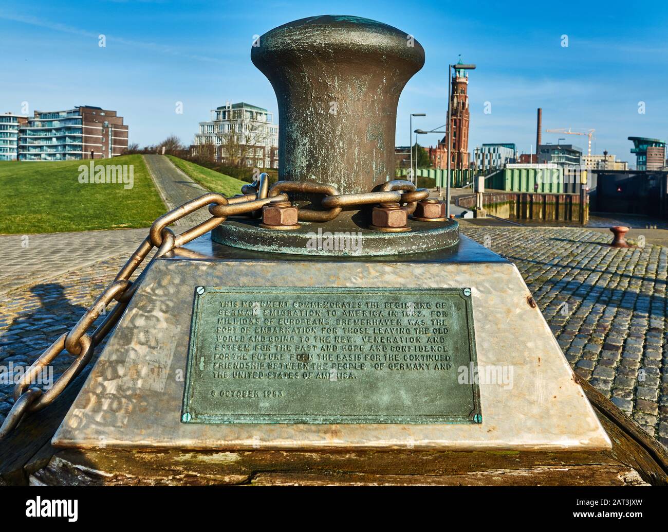 Bremerhaven, Germania, 16 gennaio 2020: Monumento fatto di una pesante catena intorno a un paletto, in memoria degli emigranti in America, con un piatto di metallo wi Foto Stock