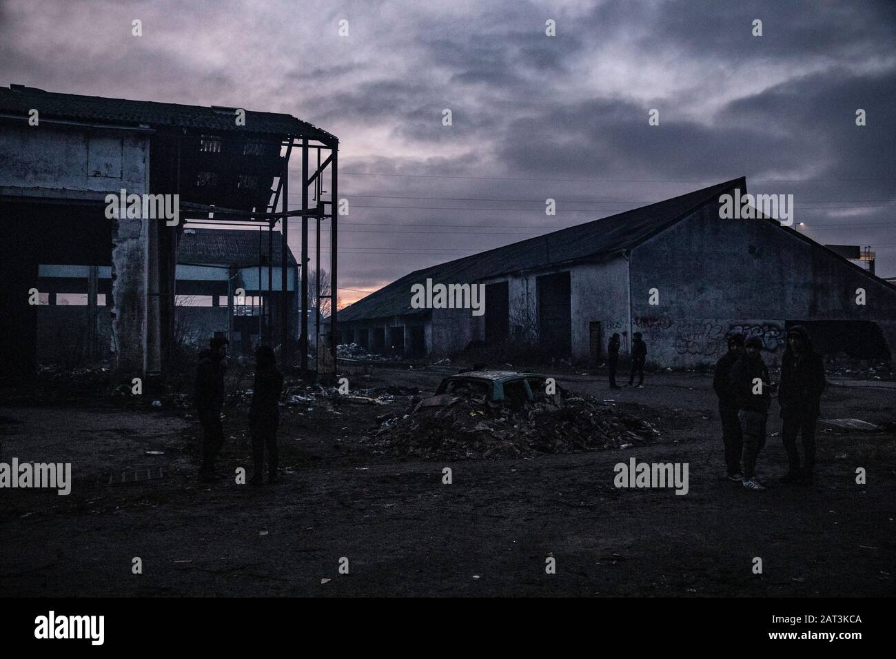 Immigrati curdi iracheni che si rifugiano in tende tra le macerie di un deposito derelict alla periferia di Dunkerque mentre cercano di raggiungere la Gran Bretagna. Foto Stock