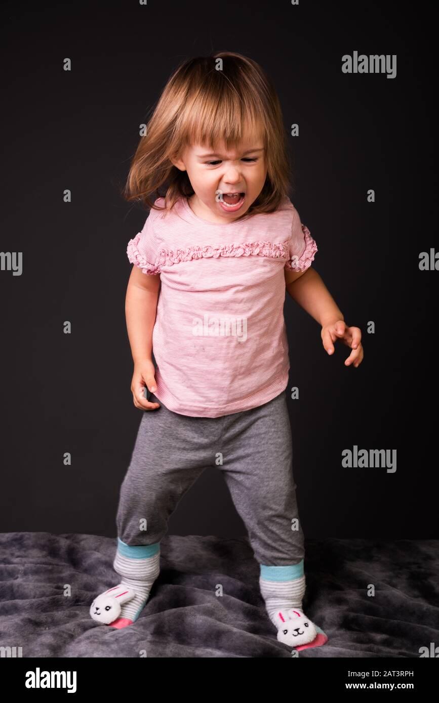 bambino di 2 anni che guarda arrabbiato in piedi isolato su sfondo bianco.  Foto ritagliata per il concetto di sviluppo delle emozioni Foto stock -  Alamy