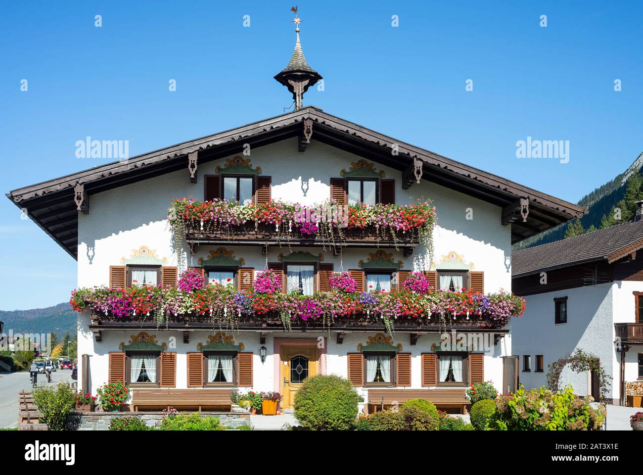 Tradizionale casa colonica tirolese con balconi, persiane e fiori in fiore in scatole a Achenkirch sul Lago Achensee, Tirolo, Austria Foto Stock