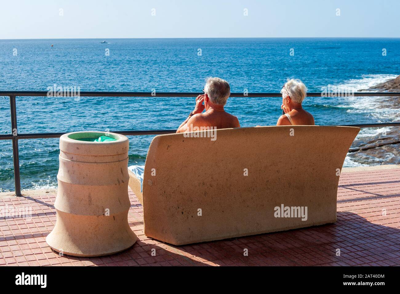 Canary ISLAND TENERIFE, SPAGNA - 27 dicembre 2019: Una coppia in pensione è seduta su una panchina godendo il sole e vista su Tenerife. Foto Stock