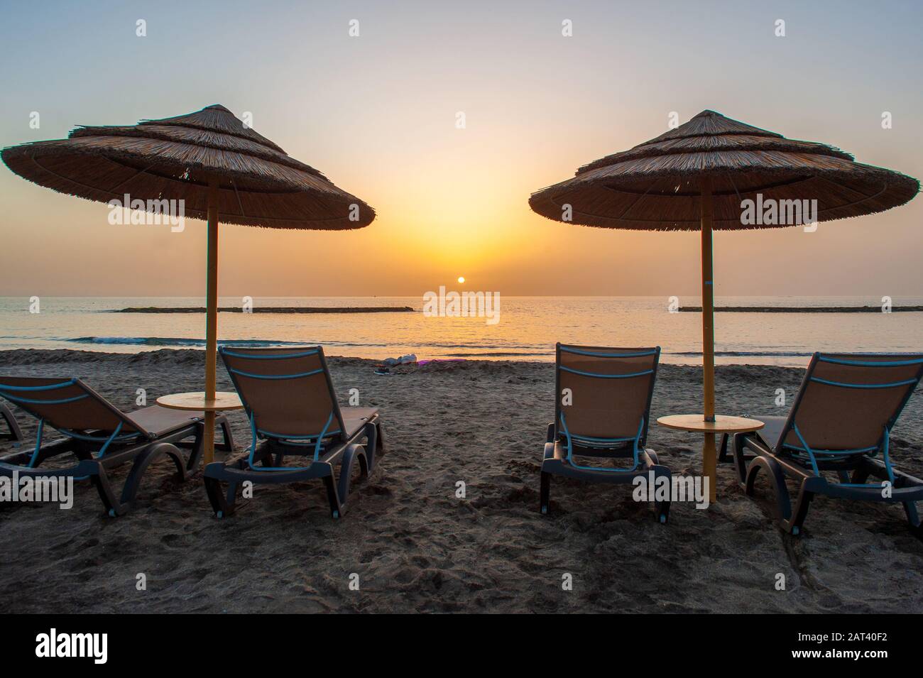 Due lettini su una spiaggia vuota poco prima del tramonto. Foto Stock