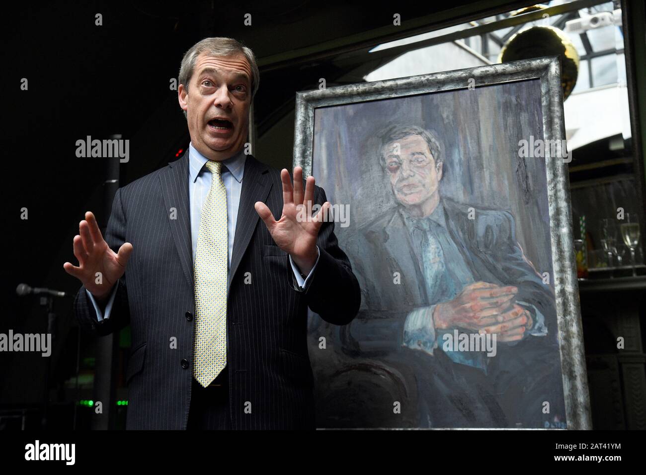 Nigel Farage si trova accanto a un ritratto di sé intitolato MR Brexit, dall'artista Dan Llywelyn Hall, al ristorante l'Escargot di Londra. Foto Stock