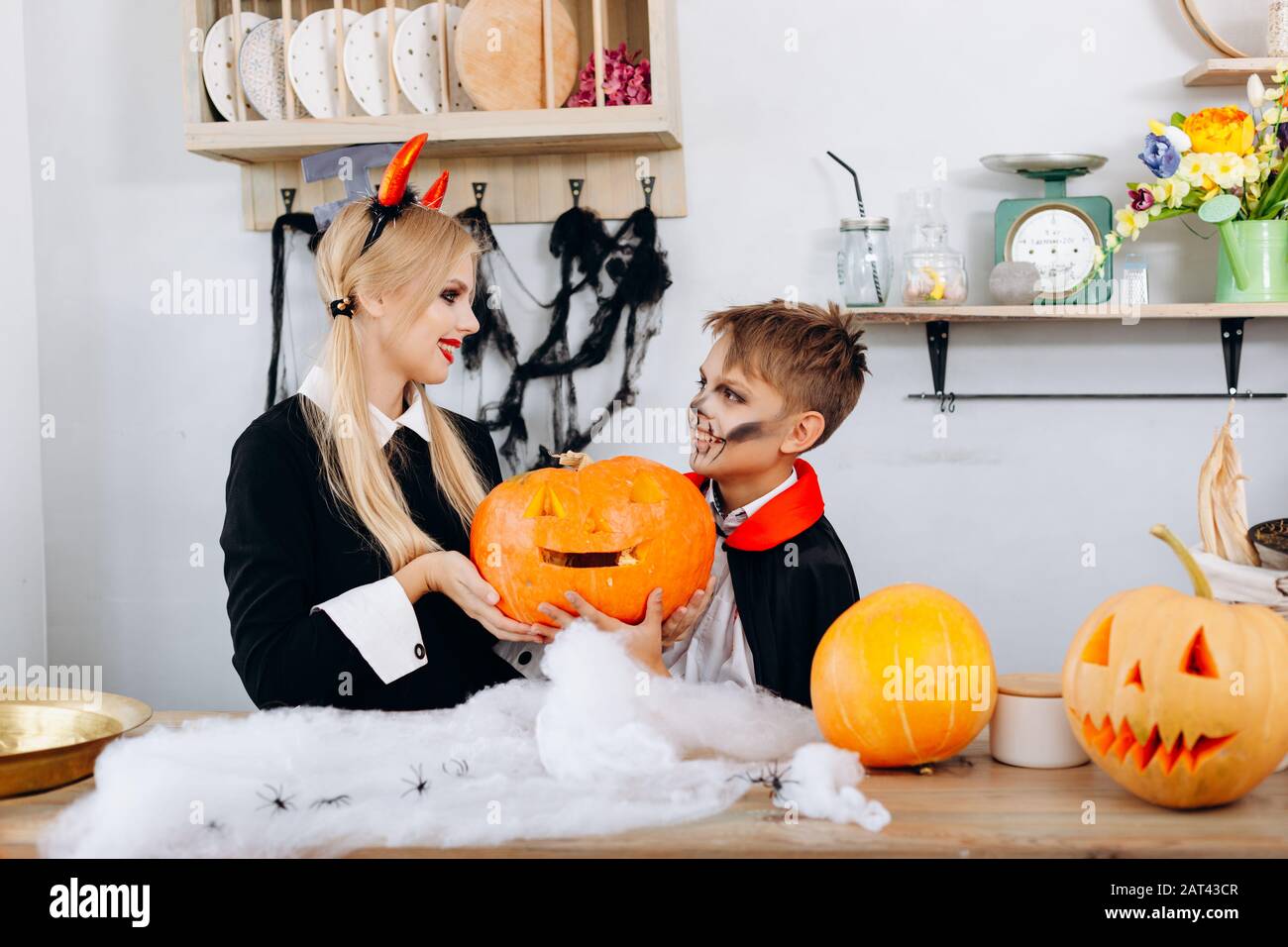 Madre e figlio che detengono una zucca durante i preparativi per Halloween. Foto Stock